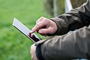 Farmer in the field with a mobile device