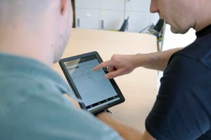men looking at graphs on tablet